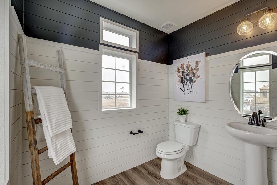 Convenience and style converge in the elegant powder room tucked just off the open-concept great room, kitchen, and dining area. Seamlessly integrated into the flow of your home, this powder room offers a touch of luxury and functionality.