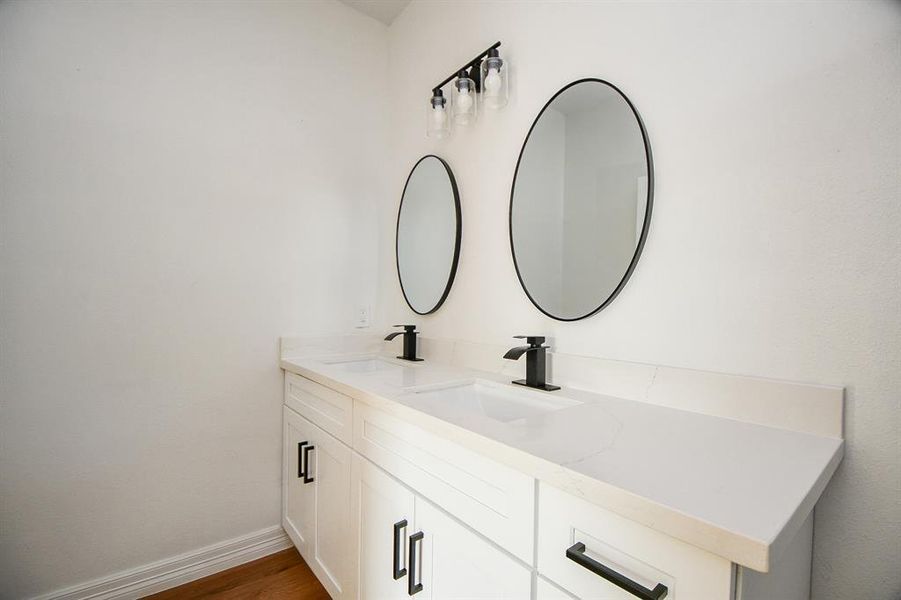 Experience the elegance of this beautifully designed bathroom. Enjoy luxurious white countertops that add a touch of sophistication. Additionally, thoughtfully designed cabinetry provides ample storage space for all your essentials, keeping the area organized.