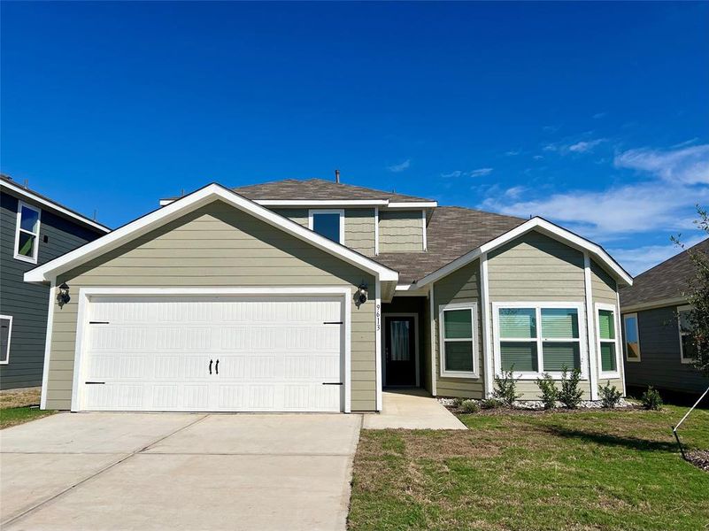 View of front of house featuring a front yard and a garage