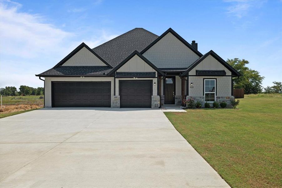 Craftmans style house featuring a front lawn and a garage