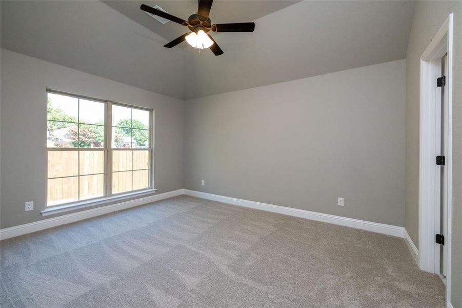 Unfurnished room featuring carpet floors, lofted ceiling, and ceiling fan