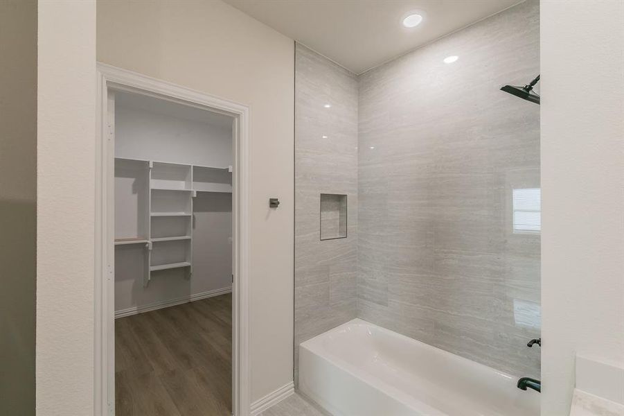 Bathroom with wood-type flooring and tiled shower / bath combo