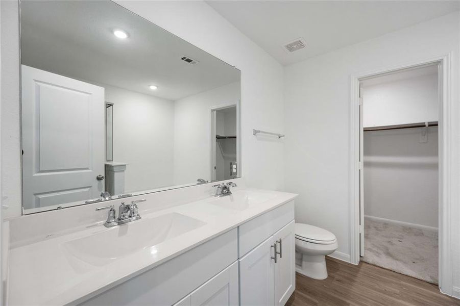 Primary ensuite bathroom with dual sinks.