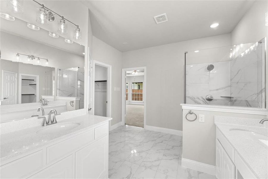 Bathroom with tiled shower, vanity, and ceiling fan