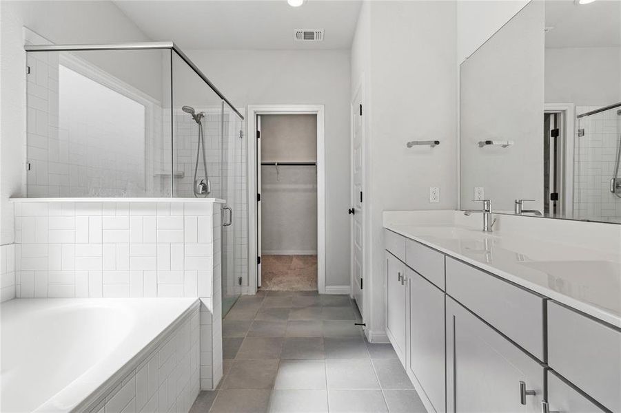 Primary bathroom with dual vanity, standalone shower, and soaking tub separate.