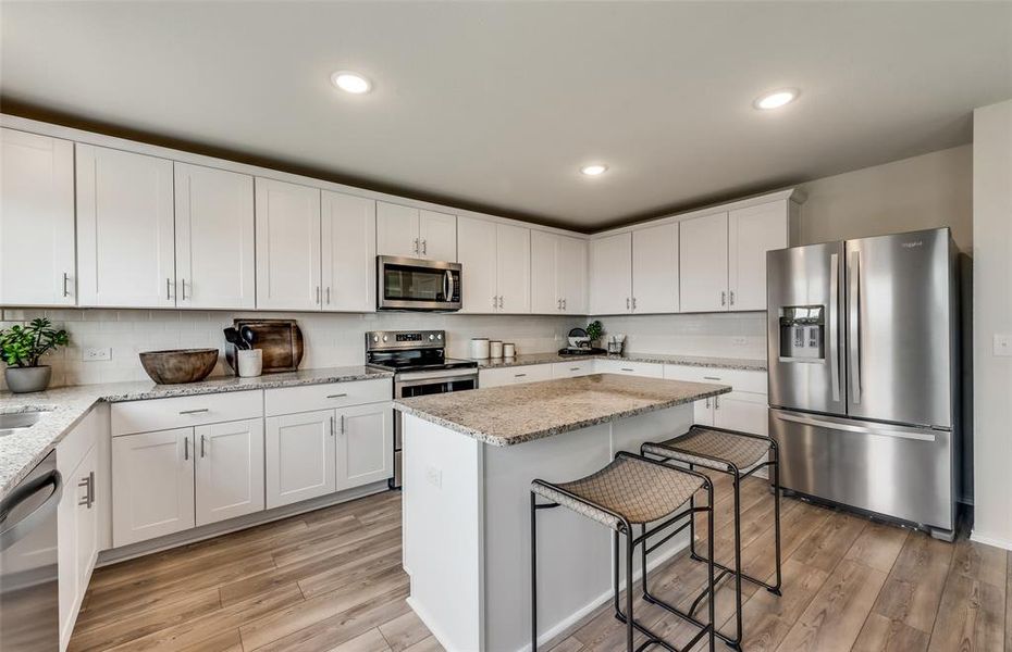 Spacious kitchen with eat-in bartop island *Photos of furnished model. Not actual home. Representative of floor plan. Some options and features may vary.