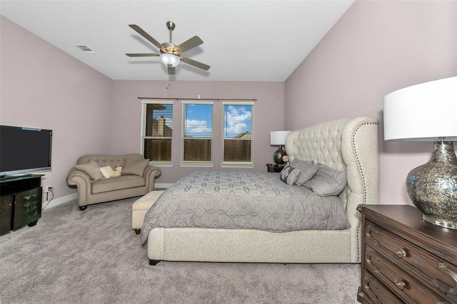 Carpeted bedroom featuring ceiling fan