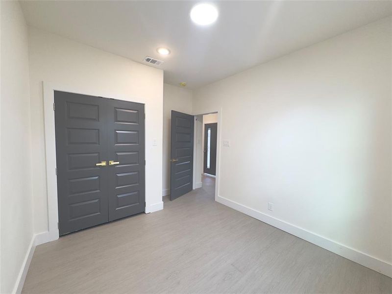 Unfurnished bedroom with light hardwood / wood-style flooring and a closet