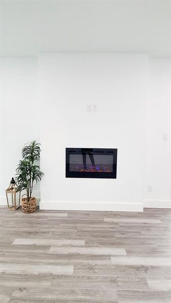 Room details featuring a fireplace appliance with hardwood / wood-style flooring