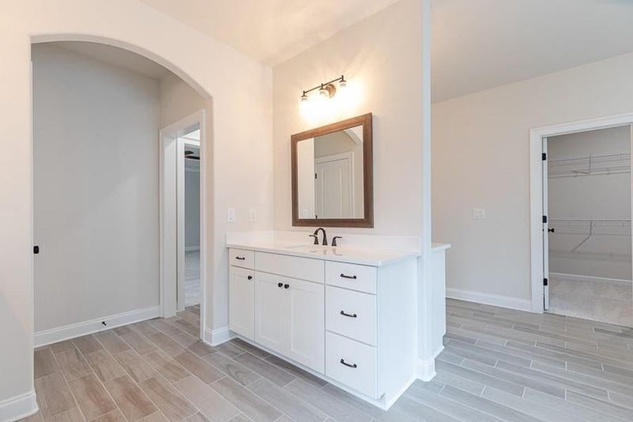 What an entrance into the owner's bathroom featuring separate vanities. Photo not actual home, but previously built Mansfield plan.