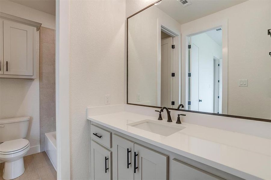 Full bathroom featuring vanity, toilet, and washtub / shower combination