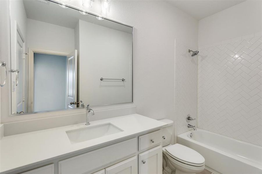 Full bathroom with vanity, toilet, and tiled shower / bath