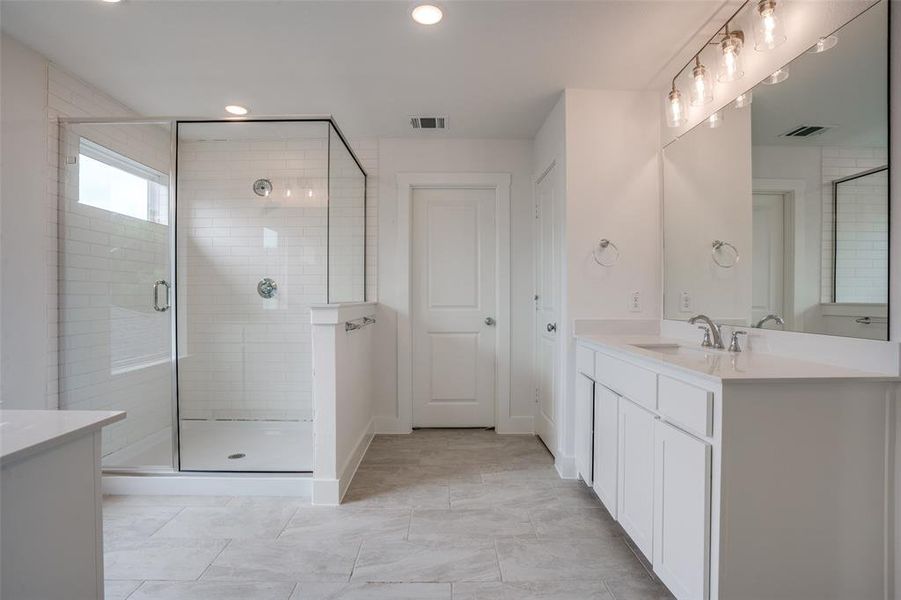 Bathroom with a shower with door, tile flooring, and vanity
