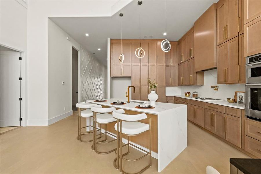 Kitchen featuring tasteful backsplash, an island with sink, stovetop, a kitchen bar, and pendant lighting