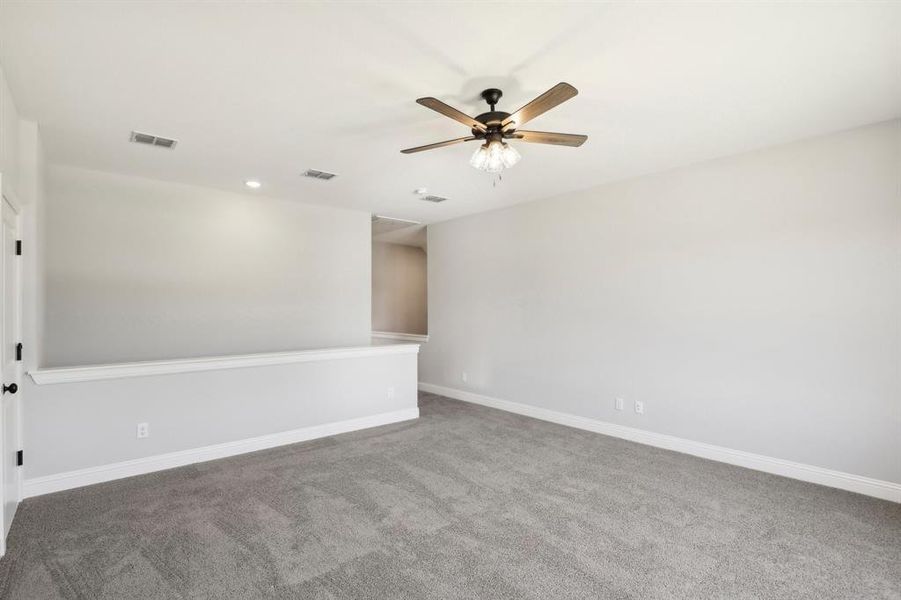 Empty room featuring carpet floors and ceiling fan