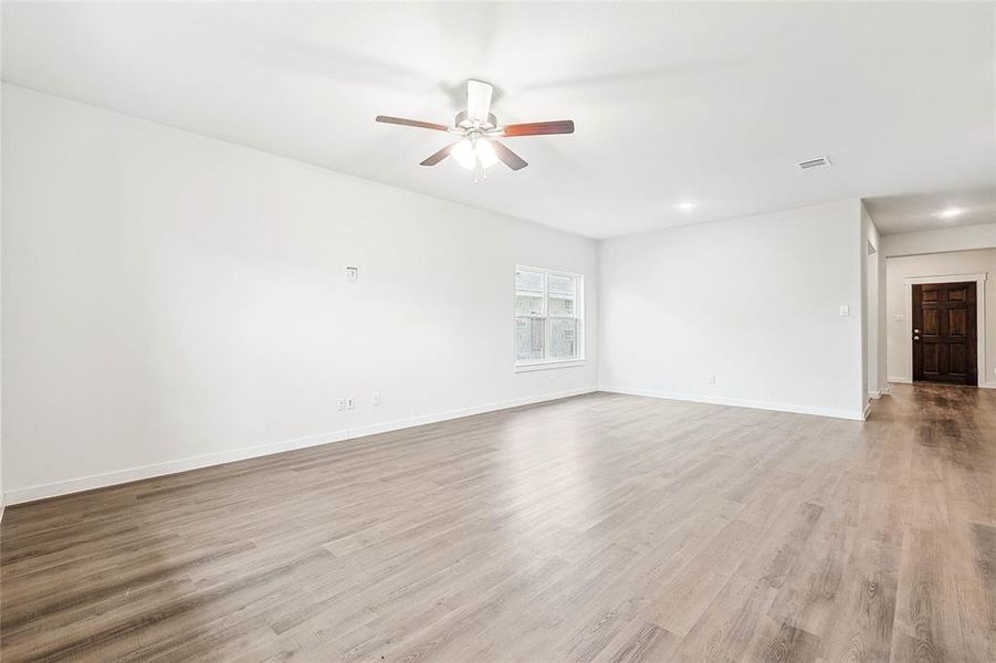 Unfurnished living room featuring ceiling fan and light hardwood / wood-style floors