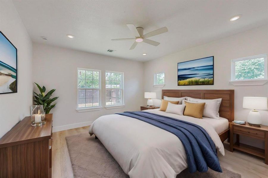 Virtually Staged Primary Bedroom featuring ceiling fan and light hardwood / wood-style flooring