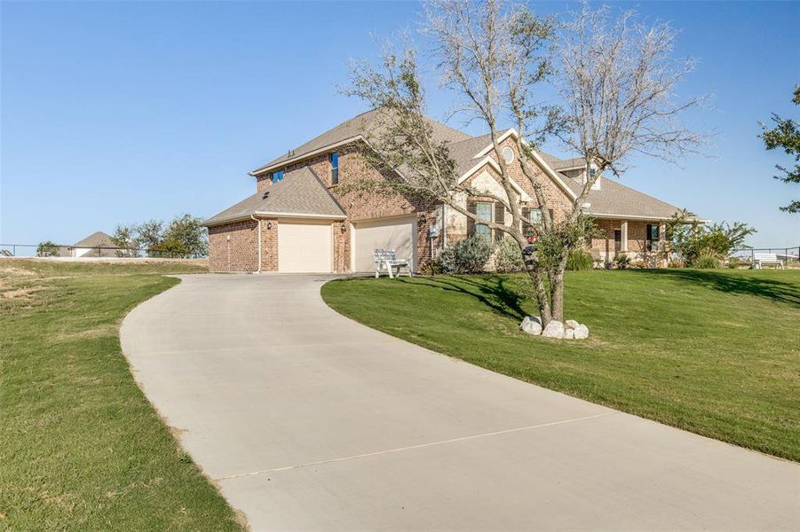 View of front facade featuring a front lawn and a garage