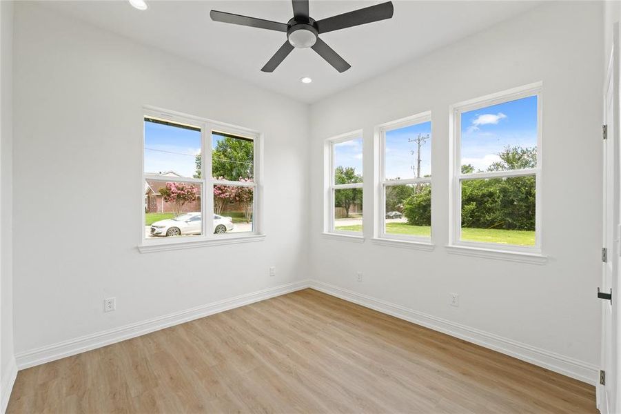 Unfurnished room with ceiling fan, a healthy amount of sunlight, and light wood-type flooring