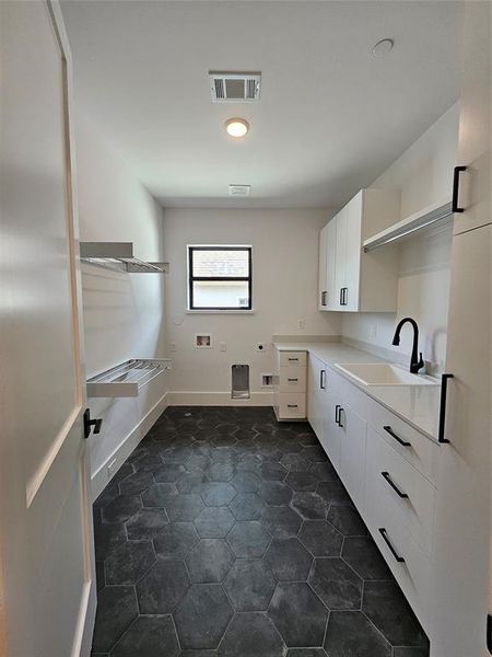 Upstairs laundry room with utility sink and lots of built-in cabinets, drawers & drying rods