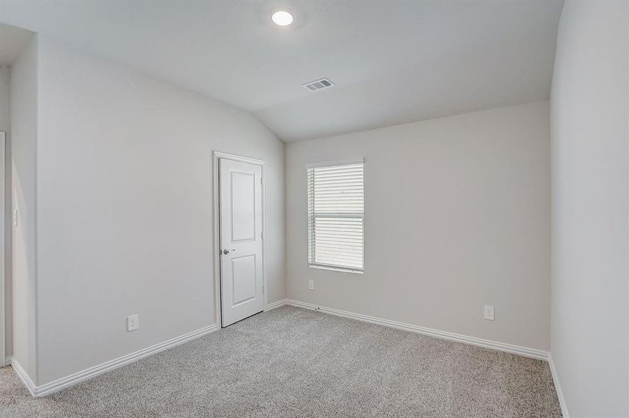 Bedroom featuring lofted ceiling and light colored carpet