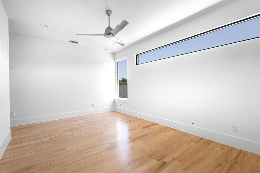 Unfurnished room with ceiling fan and light hardwood / wood-style floors