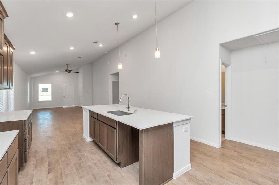 A harmonious blend of open-concept living with a direct line of sight from the spacious kitchen to the bright living area. The elongated layout, enhanced by recessed lighting and a neutral palette, makes this space perfect for both everyday living and entertaining. **This image is from another Saratoga Home - Clover floorplan.**