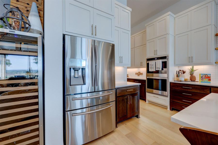 Lots of cabinets, added upscale hardware, a Double Oven, and Wine Frig can Convey!