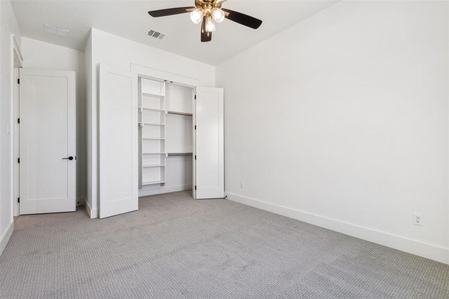 Unfurnished bedroom with light carpet, ceiling fan, and a closet