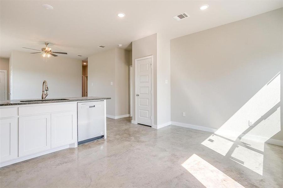 Unfurnished living room with sink and ceiling fan