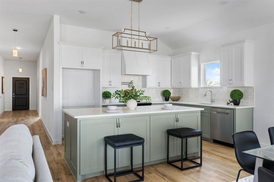 Kitchen featuring a kitchen breakfast bar, stainless steel dishwasher, hanging light fixtures, and a kitchen island