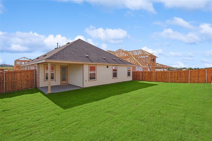 Back of house with a patio area and a lawn