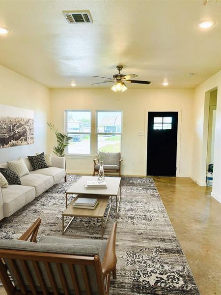 Living room featuring concrete floors, a textured ceiling, and ceiling fan