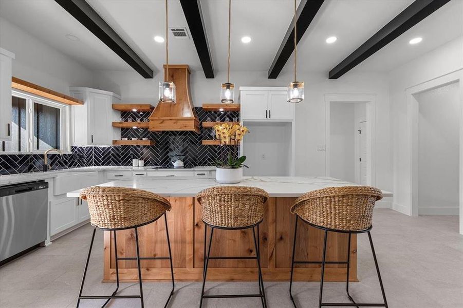 Kitchen featuring beam ceiling, white cabinetry, a kitchen island, and dishwasher