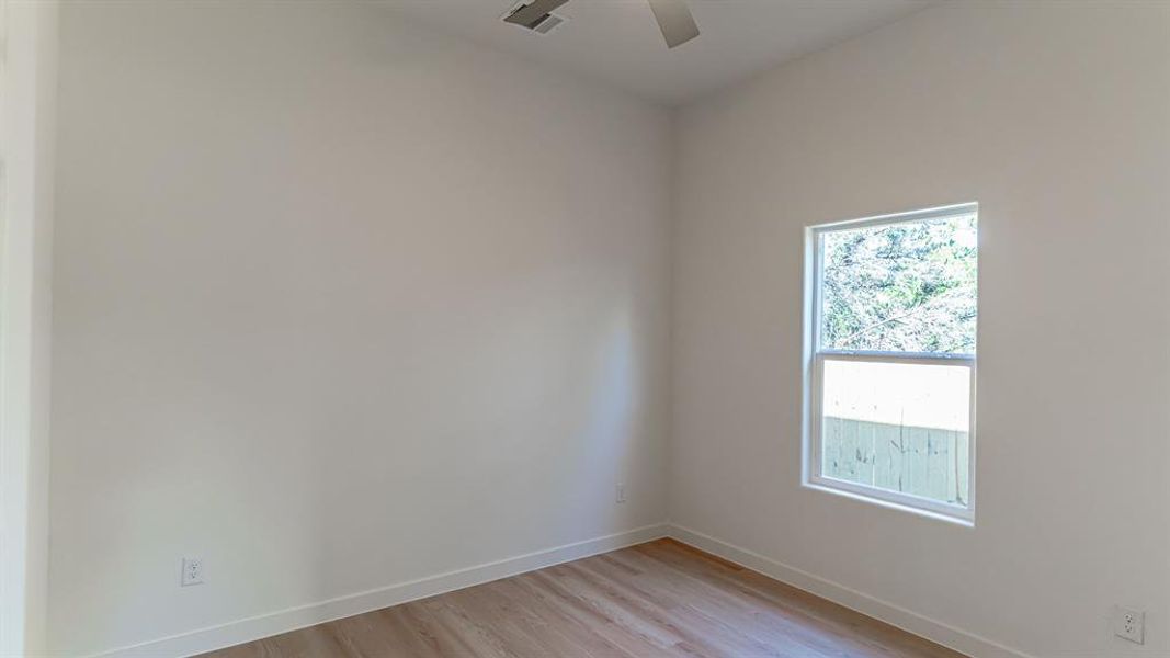 Secondary bedroom with luxury vinyl flooring and ceiling fan