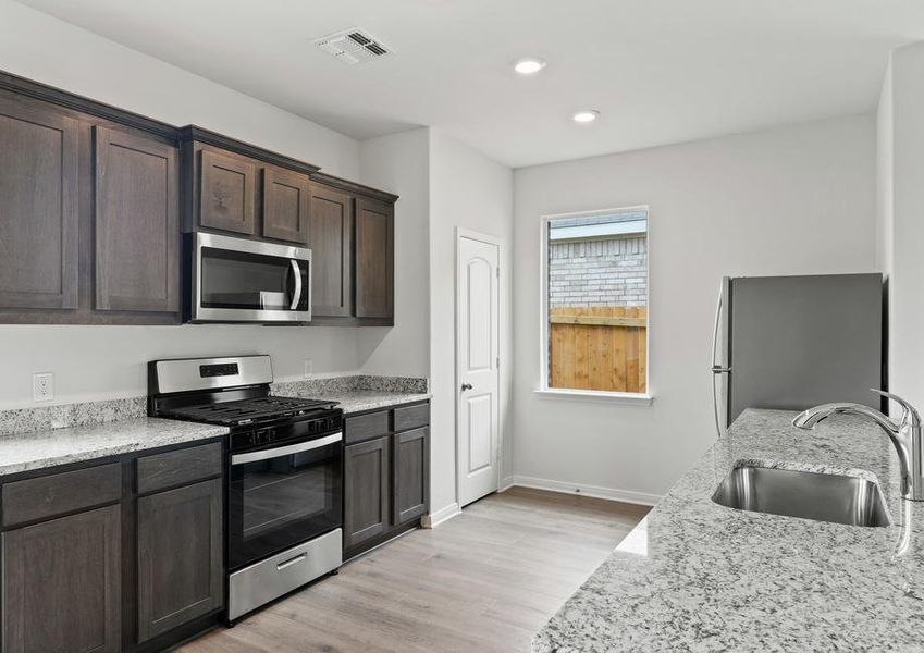 The kitchen has gorgeous wood cabinetry.