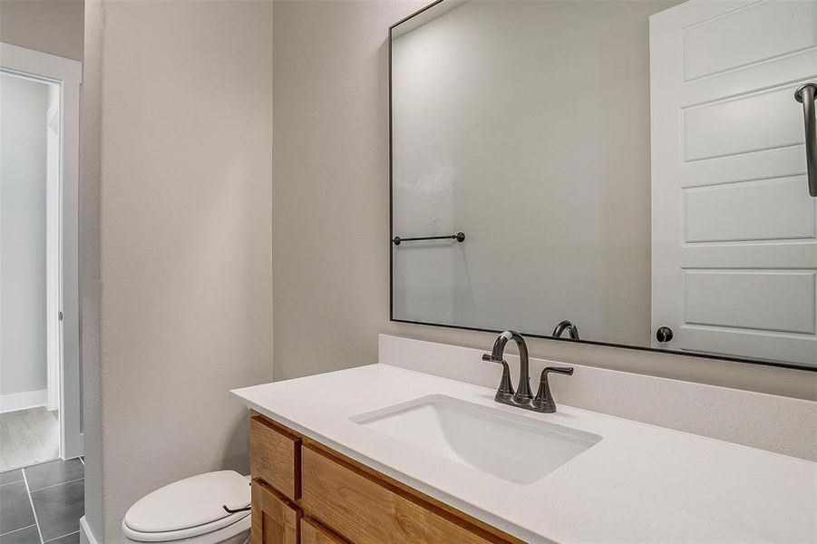 Bathroom with tile flooring, vanity, and toilet