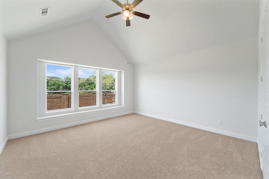 Spare room with high vaulted ceiling, light carpet, and ceiling fan