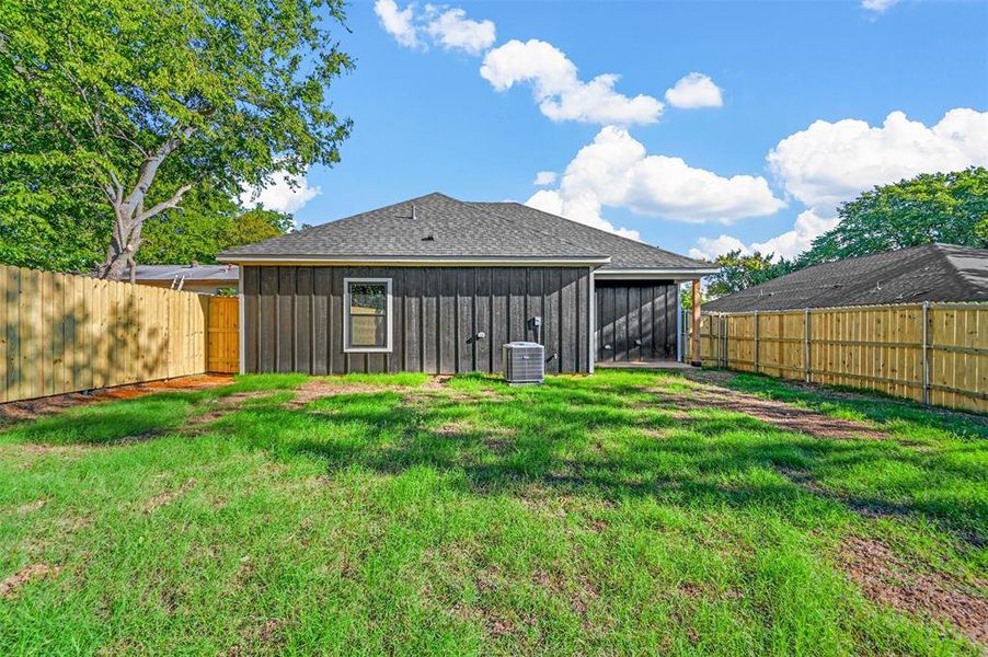 Back of house featuring a lawn and central AC unit