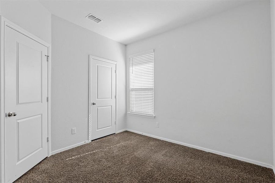 Unfurnished bedroom with dark carpet