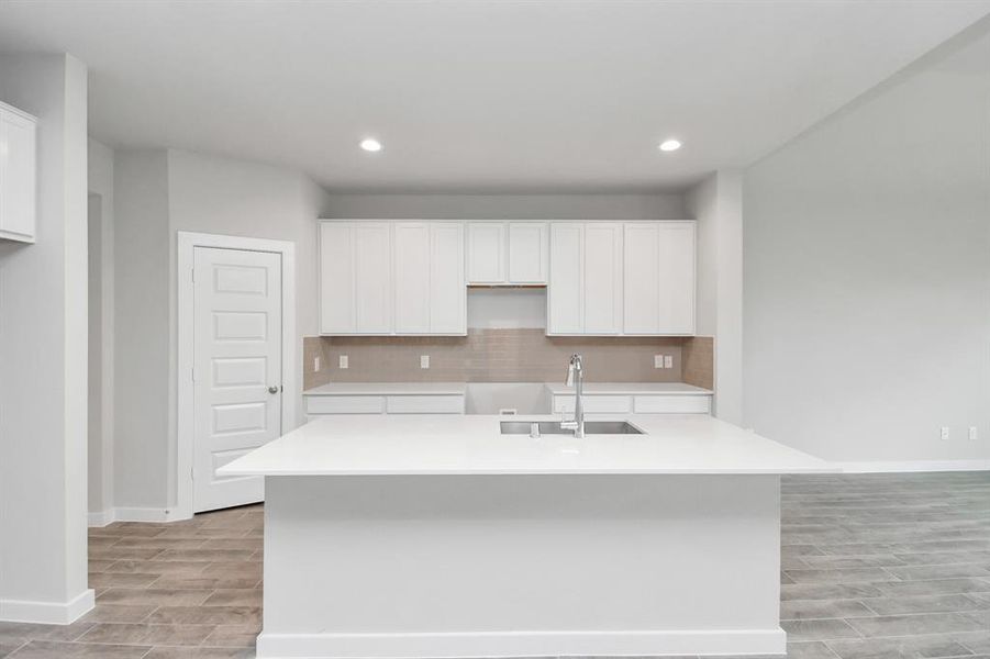 Culinary haven, featuring granite countertops, a tile backsplash, stainless steel appliances (to be installed), and 42” upper cabinets. Sample photo, actual color and selections can vary.