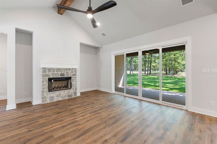 Unfurnished living room with beamed ceiling, a fireplace, and hardwood / wood-style flooring