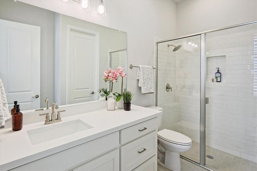 Bathroom featuring vanity, toilet, and a shower with shower door