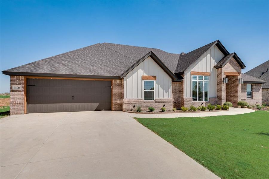 View of front of house featuring a front lawn and a garage