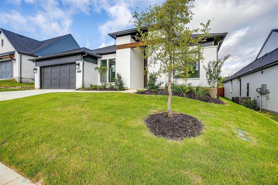 View of front of property featuring a front yard and a garage