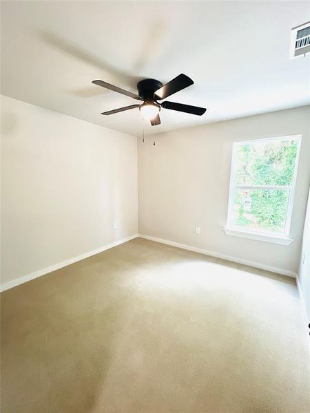 Empty room featuring carpet floors and ceiling fan