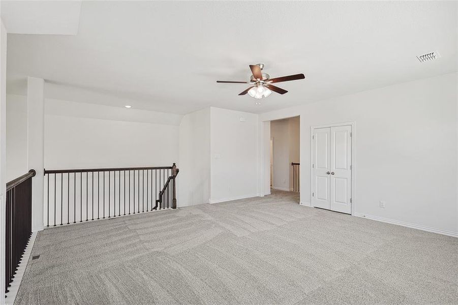 Empty room featuring ceiling fan and light colored carpet