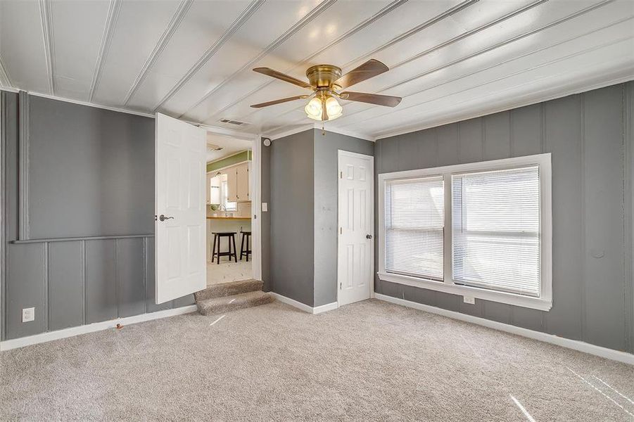 Unfurnished bedroom featuring ornamental molding, carpet, and ceiling fan