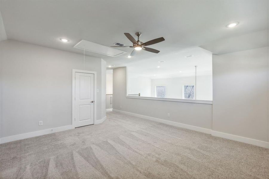 Carpeted spare room featuring ceiling fan