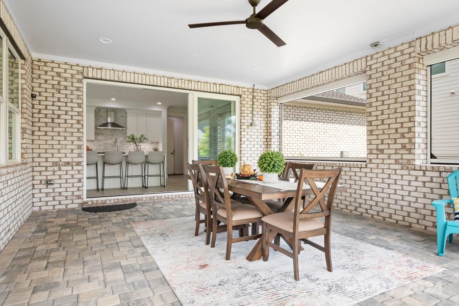 View of covered porch into Kitchen area.  Porch features a paver floor, ceiling fan and automatic screens that raise and lower via a remote control.